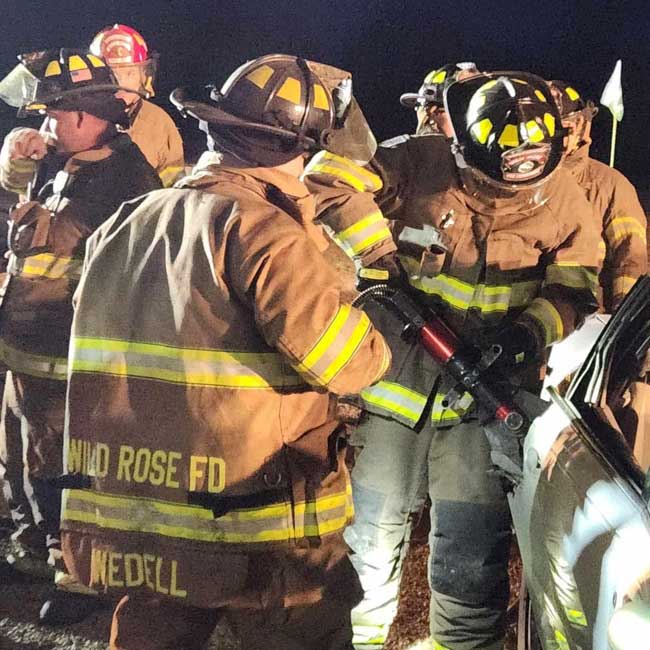 Wild Rose Area Fire District fleet and fire department firefighter use jaws of life to open car door